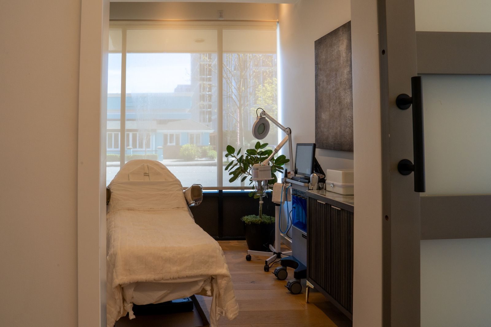 Bright Crown & Core treatment room with a cream treatment bed beside tall windows